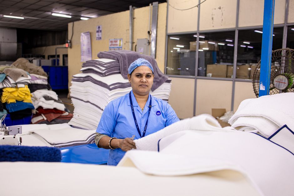 A female worker organizing textiles in a modern industrial setting.